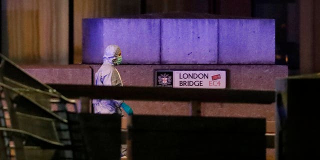 A police forensic officer walked by a sign where a man was shot dead by police on London Bridge on Friday. (AP Photo/Matt Dunham)