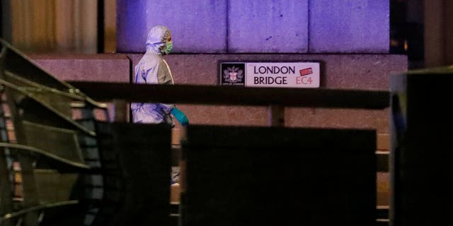 A police forensic officer walked by a sign where a man was shot dead by police on London Bridge on Friday. (AP Photo/Matt Dunham)