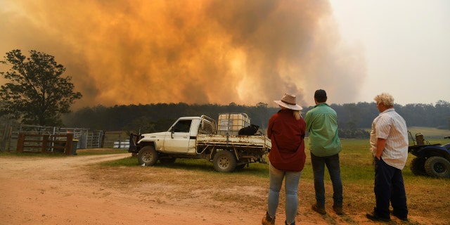 Locals watch smoke from a large bushfire outside Nana Glen, near Coffs Harbour, Tuesday, Nov. 12, 2019.