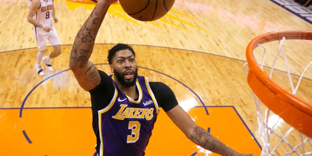 Los Angeles Lakers forward Anthony Davis scores against the Phoenix Suns during the second half during an NBA basketball game Tuesday, Nov. 12, 2019, in Phoenix. (AP Photo/Rick Scuteri)