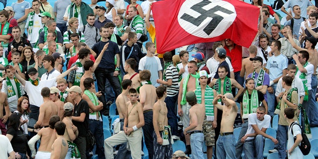 Supporters of Karpaty Lviv hold a German Nazi flag with a swastika as they attend a soccer match against Dynamo Kiev in Kiev August 19, 2007. Poland and Ukraine denounced British press allegations of racism and mob violence at soccer stadiums.