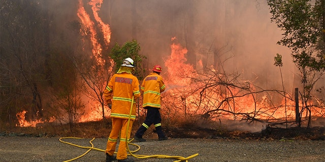 Firefighters tackle a bushfire to save a home in Taree, 350km north of Sydney on November 9, 2019 as they try to contain dozens of out-of-control blazes that are raging in the state of New South Wales. - At least two people have died and 100 homes have been destroyed as an unprecedented number of bushfires tore through eastern Australia. (Photo by PETER PARKS / AFP) (Photo by PETER PARKS/AFP via Getty Images)