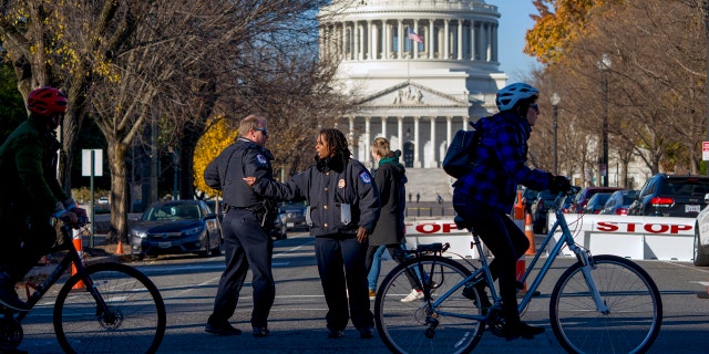 Officers direct passerby to keep at a safe distance from the U.S. Capitol Tuesday. (AP Photo/J. Scott Applewhite)