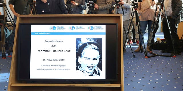 In this Friday, Nov. 15, 2019 photo a picture of Claudia Ruf is seen on a video screen as jounalists wait for the start of a press conference in Grevenbroich, Germany. Police in the western German city of Grevenbroich have asked about 900 men to come forward and have their DNA tested to help solve the gruesome killing of an 11-year-old girl decades ago. The girl, Claudia Ruf, was kidnapped, raped and choked to death by an anonymous murderer in 1996. (Roland Weihrauch/dpa via AP)