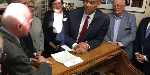 Democratic presidential candidate Sen. Cory Booker of New Jersey Statehouse hands over a $1,000 check to longtime New Hampshire Secretary of State Bill Gardner as he files place his name on the first-in-the-nation presidential primary, in Concord, NH on Nov. 15, 2019