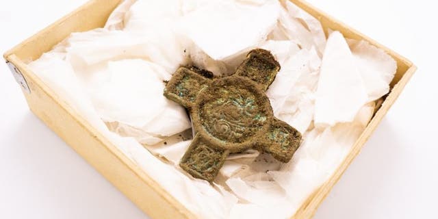 The crucifix-shaped brooch, made from an Irish harness fitting, which was in the woman's grave.