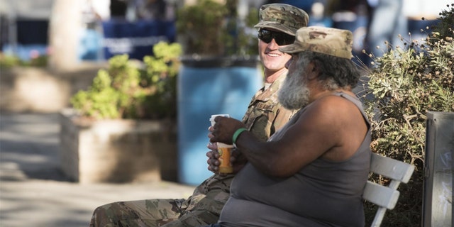 Staff Sgt. Robert Gross sat with a homeless veteran during the Santa Barbara Stand Down. (U.S. Air Force photo by Airman 1st Class Hanah Abercrombie)