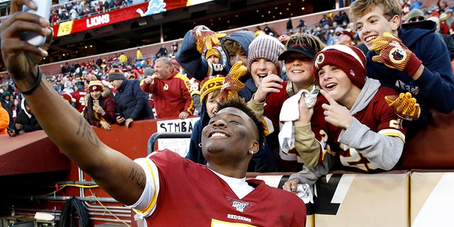 Washington Redskins quarterback Dwayne Haskins taking a selfie with fans during the second half of the game against the Detroit Lions on Sunday. (AP Photo/Patrick Semansky)