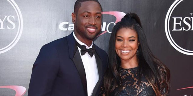 Gabrielle Union and husband Dwyane Wade pose for cameras.