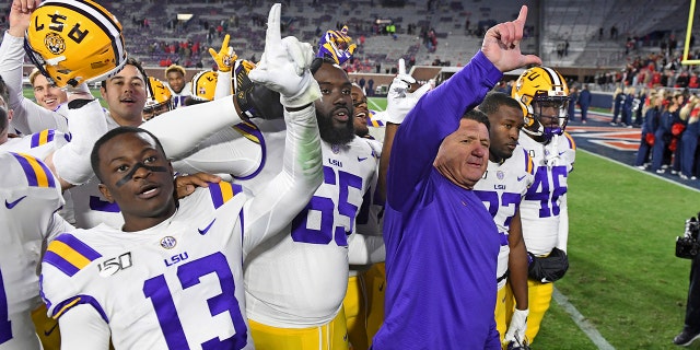 LSU coach Ed Orgeron and players celebrate after an NCAA college football game against Mississippi in Oxford, Miss., Saturday, Nov. 16, 2019. No. 1 LSU won 58-37. (AP Photo/Thomas Graning)