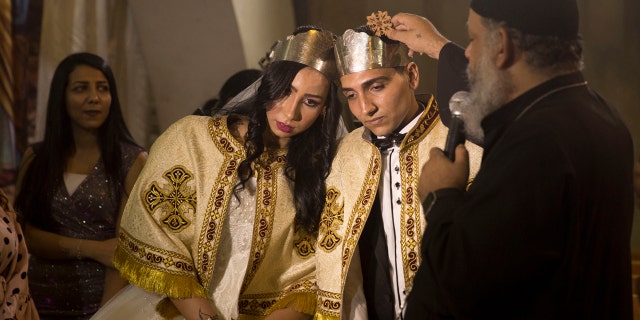 In this June 15, 2019, photo, a Coptic priest blesses an Egyptian couple during their wedding in St. Samaan’s Church, in the predominantly Christian Manshiyat Nasser area of Cairo (AP Photo/Maya Alleruzzo)