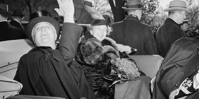 First lady Eleanor Roosevelt smiles President Franklin D. Roosevelt's side, as he waves a greeting to the crowd which cheered him as he left St. John's Church in Washington, Jan. 20, 1941, his third inaugural day. (AP Photo)