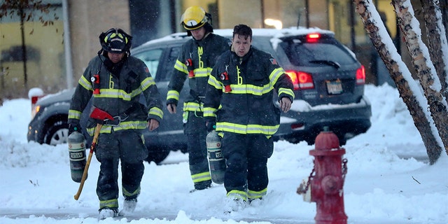 Minneapolis firefighters leave high-rise apartment building after a deadly fire Wednesday. (David Joles/Star Tribune via AP)