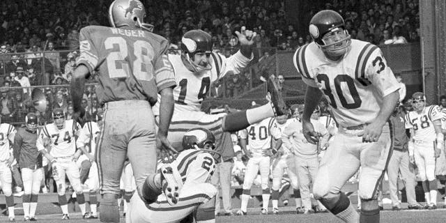 FILE - In this Sunday, Nov. 1, 1970 file photo, Minnesota Vikings Fred Cox (14) kicks a field goal from near the twenty-eight yard line on score three points in first quarter of an NFL football game against the Detroit Lions in Detroit. Fred Cox, the former Minnesota Vikings kicker who co-created the Nerf football, has died. He was 80. The Vikings announced Cox’s death Thursday, Nov. 21, 2019. (AP Photo/File)