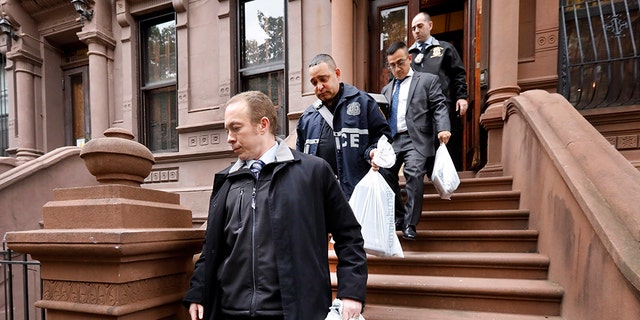 New York City Police Department personnel carry bags from a residential building in New York's Harlem neighborhood, Thursday, Nov. 7, 2019. (Associated Press)