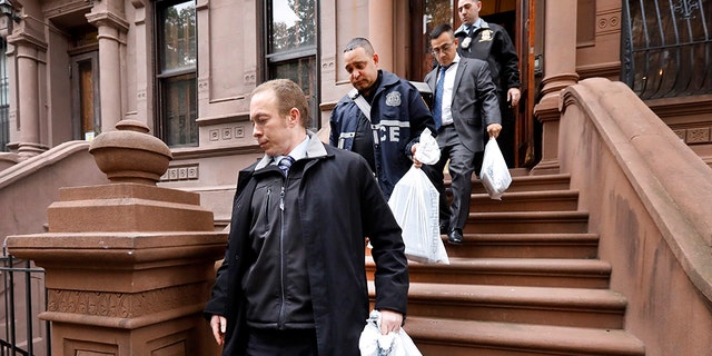 New York City Police Department personnel carry bags from a residential building in New York's Harlem neighborhood, Thursday, Nov. 7, 2019. (Associated Press)