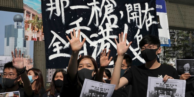 Pro-democracy students hold up their hands representing five demands at the University of Hong Kong, Wednesday, Nov. 6, 2019, as they rally against police brutality.