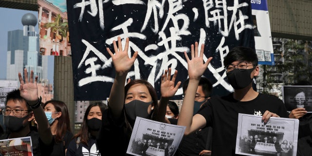 Pro-democracy students hold up their hands representing five demands at the University of Hong Kong, Wednesday, Nov. 6, 2019, as they rally against police brutality.