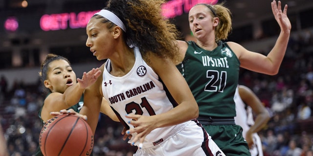 South Carolina's Harrigan Herbert (21) drives along the baseline while defended by South Carolina-Upstate's Riley Popplewell (21) and Maya Timberlake during the first half of an NCAA college basketball game Thursday, Nov. 21, 2019, in Columbia, S.C. (AP Photo/Richard Shiro)