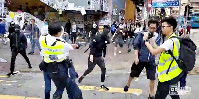 A still image from video showed a police officer aiming his gun as a protester in Hong Kong on Monday morning.