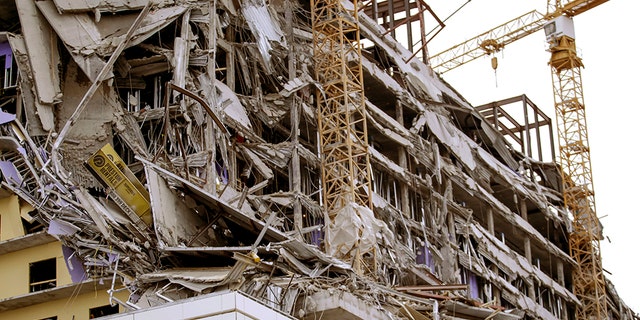 Debris hangs on the side of the building after a large portion of a hotel under construction suddenly collapsed in New Orleans on Saturday, Oct. 12, 2019. Several construction workers had to run to safety as the Hard Rock Hotel, which has been under construction for the last several months, came crashing down. It was not immediately clear what caused the collapse or if anyone was injured. (Scott Threlkeld/The Advocate via AP)