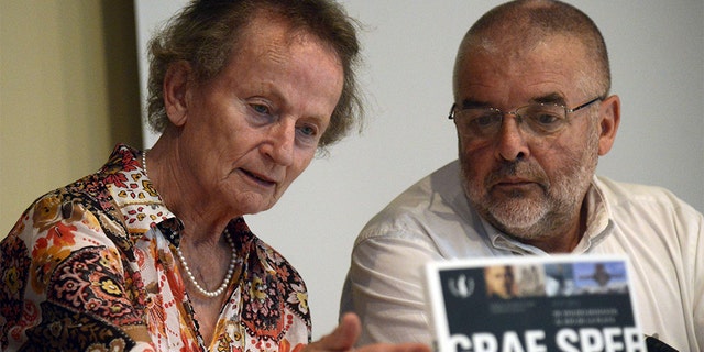 German Inge Nedden (L), daughter of German WWII battleship Graf Spee's captain Hans Langsdorff, and Uruguayan writer Daniel Acosta y Lara (R) present his and Federico Leicht's book "Graf Spee, from Wilhelmshaven to the River Plate", during the commemoration of the 75th anniversary of the Battle of the River Plate in Montevideo on December 13, 2014.