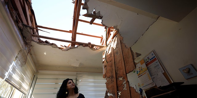 A woman surveys the damage to a house in Sderot, Israel, after it was hit by a rocket fired from Gaza Strip Tuesday.