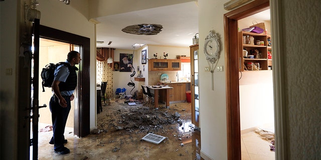 A policeman checks the damage to a house hit by a rocket fired from Gaza Strip in Netivot Tuesday.