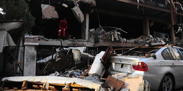 A Syrian official checks the damage of a building targeted by Israeli missile strikes in Damascus early Tuesday.