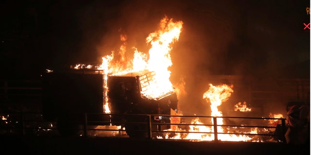 An armored police vehicle catches fire after being hit by Molotov cocktails thrown by protesters in Hong Kong on Sunday.