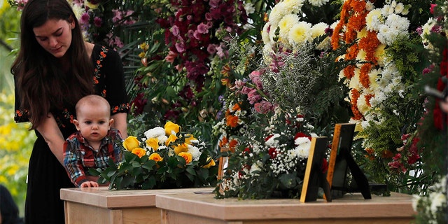 A woman and child stood by the coffins of Dawna Ray Langford, 43, and her sons Trevor, 11, and Rogan, 2, who were killed by drug cartel gunmen on Monday. (Associated Press)