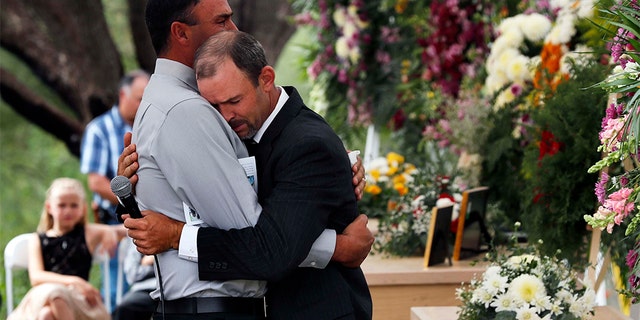 Men embraced at the first funeral for three victims of the Mexican cartel massacre. (AP Photo/Marco Ugarte)