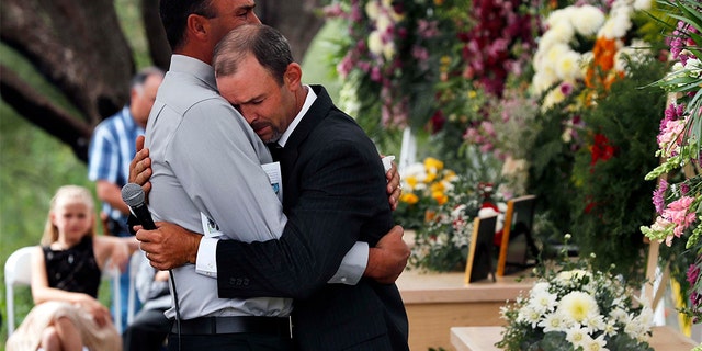 Men embraced at the first funeral for three victims of the Mexican cartel massacre. (AP Photo/Marco Ugarte)