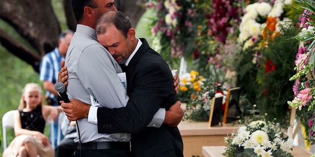 Men embrace next to the coffins of Dawna Ray Langford, 43, and her sons Trevor, 11, and Rogan, 2, who were killed by drug cartel gunmen, during the funeral at a family cemetery in La Mora, Sonora state, Mexico, Thursday, Nov. 7, 2019. Three women and six of their children, all members of the extended LeBaron family, died when they were gunned down in an attack while traveling along Mexico's Chihuahua and Sonora state border on Monday. 