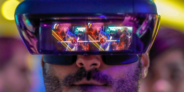 A visitor tries out Lenovo augmented reality glasses with the Star Wars Jedi Challenges during the Mobile World Congress in Barcelona, Spain, February 26, 2018. REUTERS/Yves Herman TPX IMAGES OF THE DAY - RC1EAA1E2450