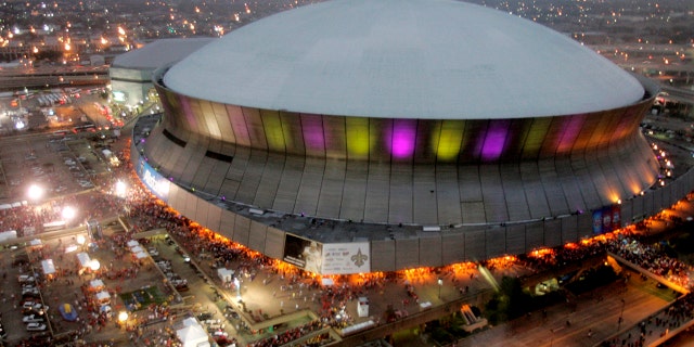 FILE - In this Jan. 7, 2008, file photo, color lights play on the Louisiana Superdome at twilight before the BCS championship college football game in New Orleans. The state board that oversees Louisiana’s Superdome approved a contract Thursday, Nov. 14, 2019, for the first phase of a $450 million renovation of the 44-year-old New Orleans landmark. (AP Photo/Rob Carr, File)