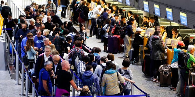 Lufthansa passengers wait in line at an airport in Frankfurt, Germany, amid the cabin crew's strike on Thursday.