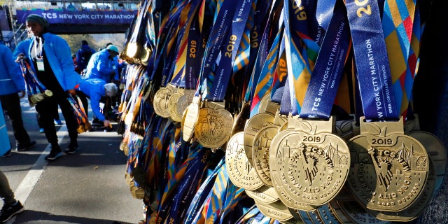Volunteers hang medals for the finishers of the New York City Marathon, in New York's Central Park, Sunday, Nov. 3, 2019.