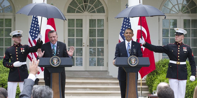 Former President Barack Obama and Turkish Prime Minister Recep Erdogan hold a joint press conference in the Rose Garden in 2013 as Marines shield them from the rain. (SAUL LOEB/AFP via Getty Images, File)