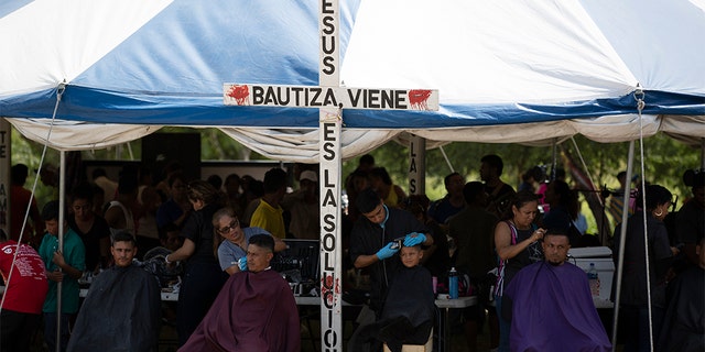 Volunteers giving migrants free haircuts at a camp near a legal port of entry bridge in Matamoros, Mexico, last month. (AP Photo/Fernando Llano, File)