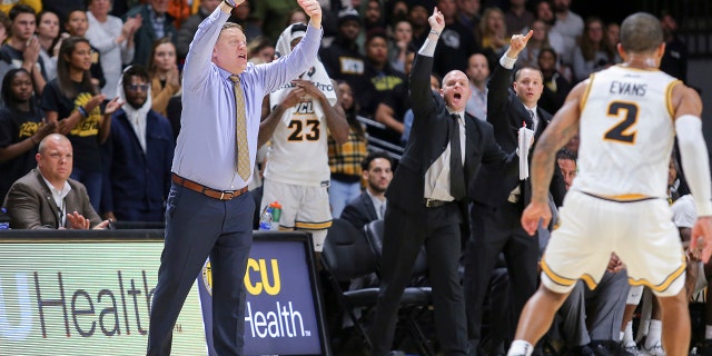 VCU coach Mike Rhoades, left, and other players on the VCU bench react to a play during the second half of an NCAA college basketball game against North Texas in Richmond, Va., Friday, Nov. 8, 2019. (AP Photo/Parker Michels-Boyce)