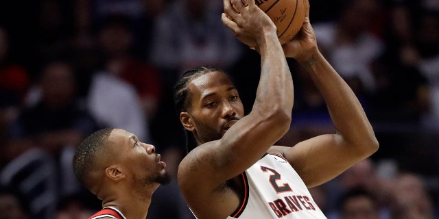 Los Angeles Clippers' Kawhi Leonard (2) is defended by Portland Trail Blazers' Damian Lillard during the first half of an NBA basketball game Thursday, Nov. 7, 2019, in Los Angeles. (AP Photo/Marcio Jose Sanchez)