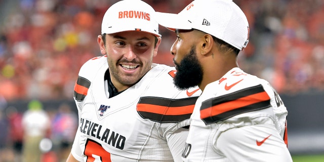 FILE - In this Aug. 8, 2019, file photo, Cleveland Browns' Baker Mayfield, left, smiles as he talks with wide receiver Odell Beckham Jr. during the second half of an NFL preseason football game against the Washington Redskins in Cleveland. Beckham believes the Browns offense will come around. Until then, he’s going to defend Mayfield. (AP Photo/David Richard, File)