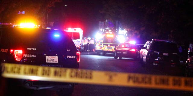 Police and emergency vehicles work at the scene of a shooting at a backyard party, Sunday, Nov. 17, 2019, in southeast Fresno, Calif. (Larry Valenzuela/The Fresno Bee via AP)