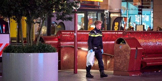 A Dutch police officer secures a bag with items from the scene of a stabbing incident in the center of The Hague, Netherlands. (AP Photo/Phil Nijhuis)