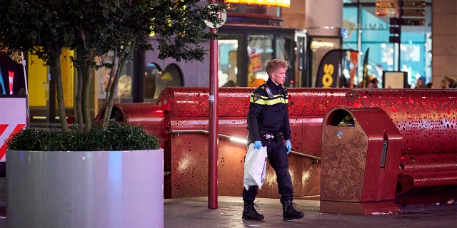 A Dutch police officer secures a bag with items from the scene of a stabbing incident in the center of The Hague, Netherlands. (AP Photo/Phil Nijhuis)