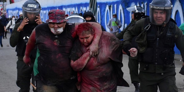Police rescue Vinto mayor Patricia Arce Guzman after people threw paint and dirt on her following a fire in Vinto's Town Hall, Quillacollo, Bolivia, November 6, 2019, in this image obtained from Los Tiempos Bolivia social media.