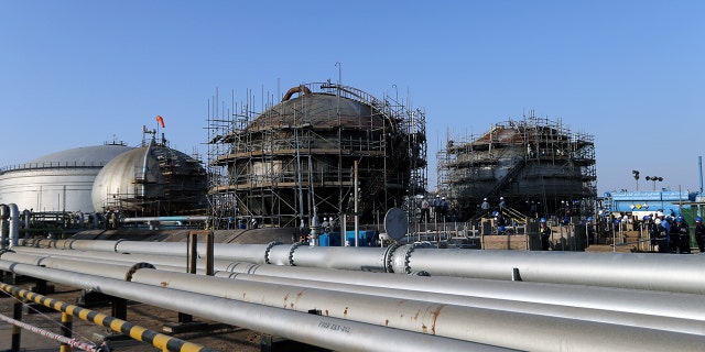 Workers are seen at the damaged site of Saudi Aramco oil facility in Abqaiq, Saudi Arabia, in September.