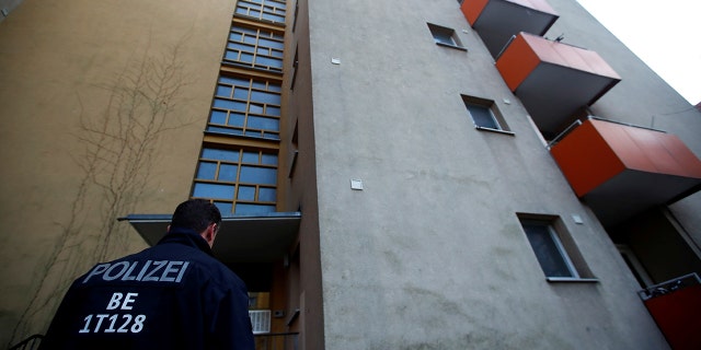A German police officer stood outside the house of a Syrian man suspected of exchanging bomb-building material after the man's arrest Tuesday in Berlin. (REUTERS/Hannibal Hanschke)