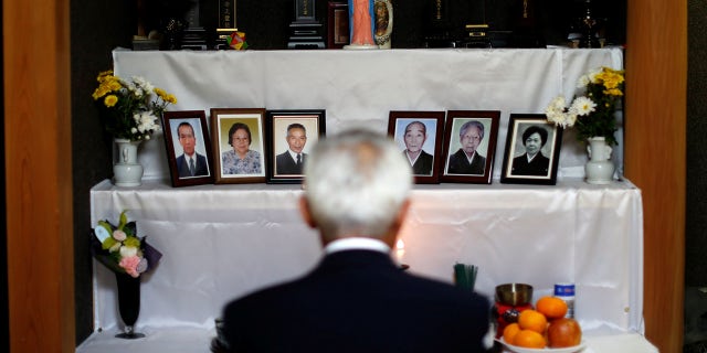 Shigenori Murakami, 69, the seventh-generation head of a group of 'Hidden Christians' chants 'orasho' in front of an altar adorned with a statue of the Virgin Mary and photos of deceased relatives at his home in Nagasaki, southern Japan, November 3, 2019. REUTERS/Issei Kato SEARCH